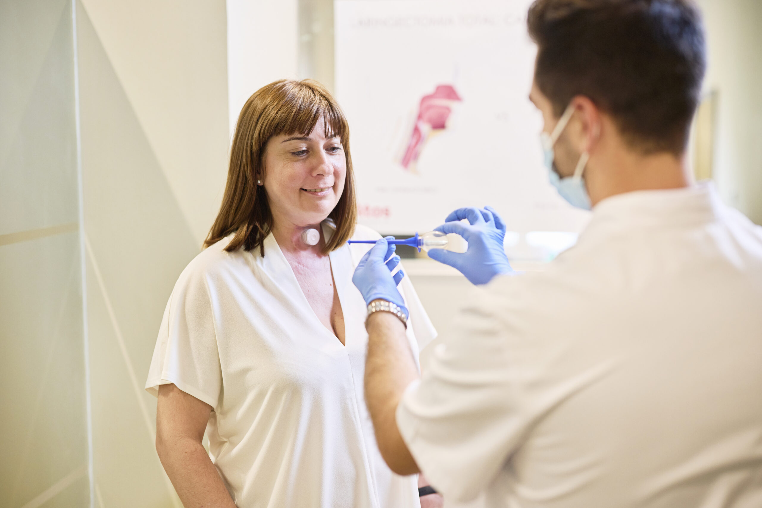 healthcare professional helps patient with neck stoma cleaning